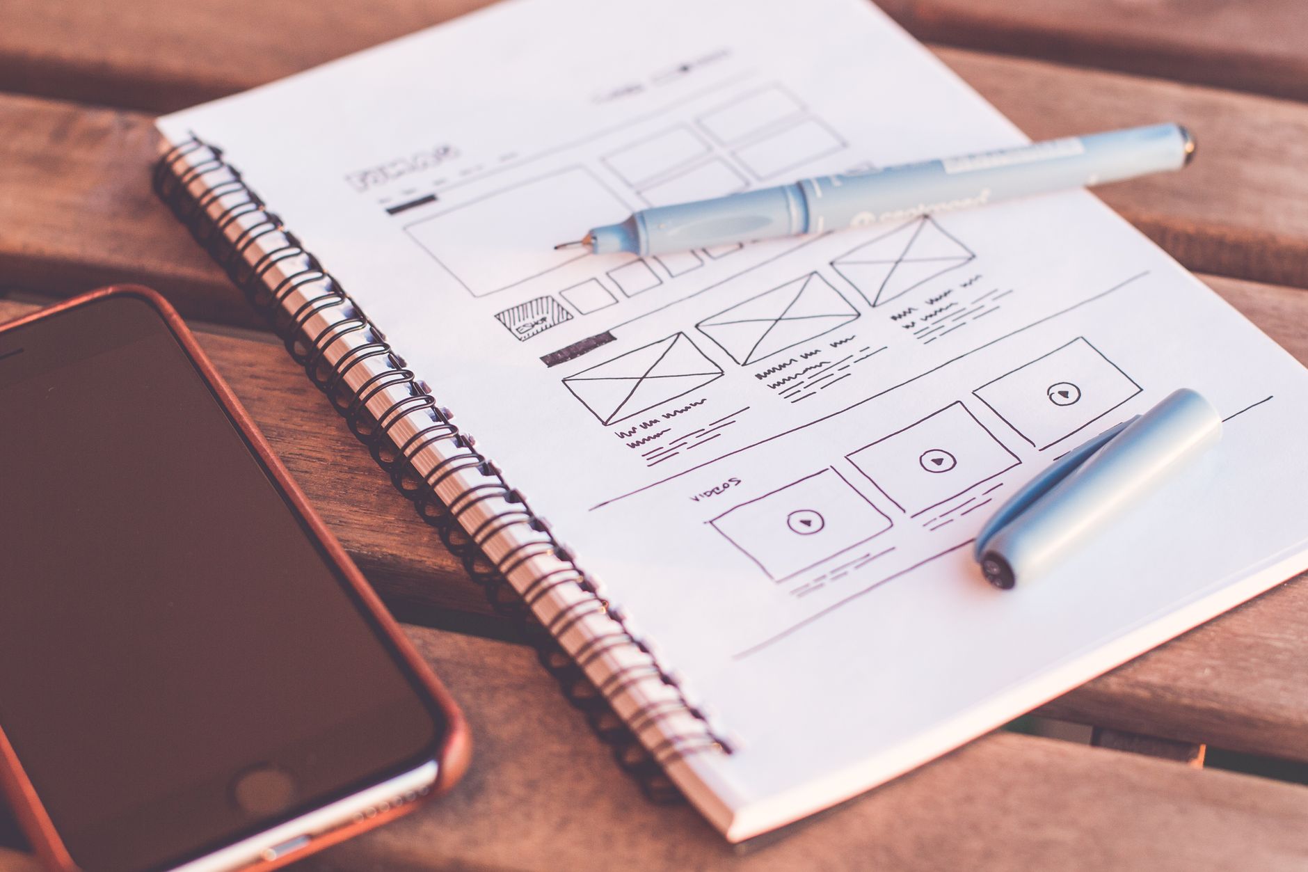 Printed website wireframes and sticky notes spread on a desk