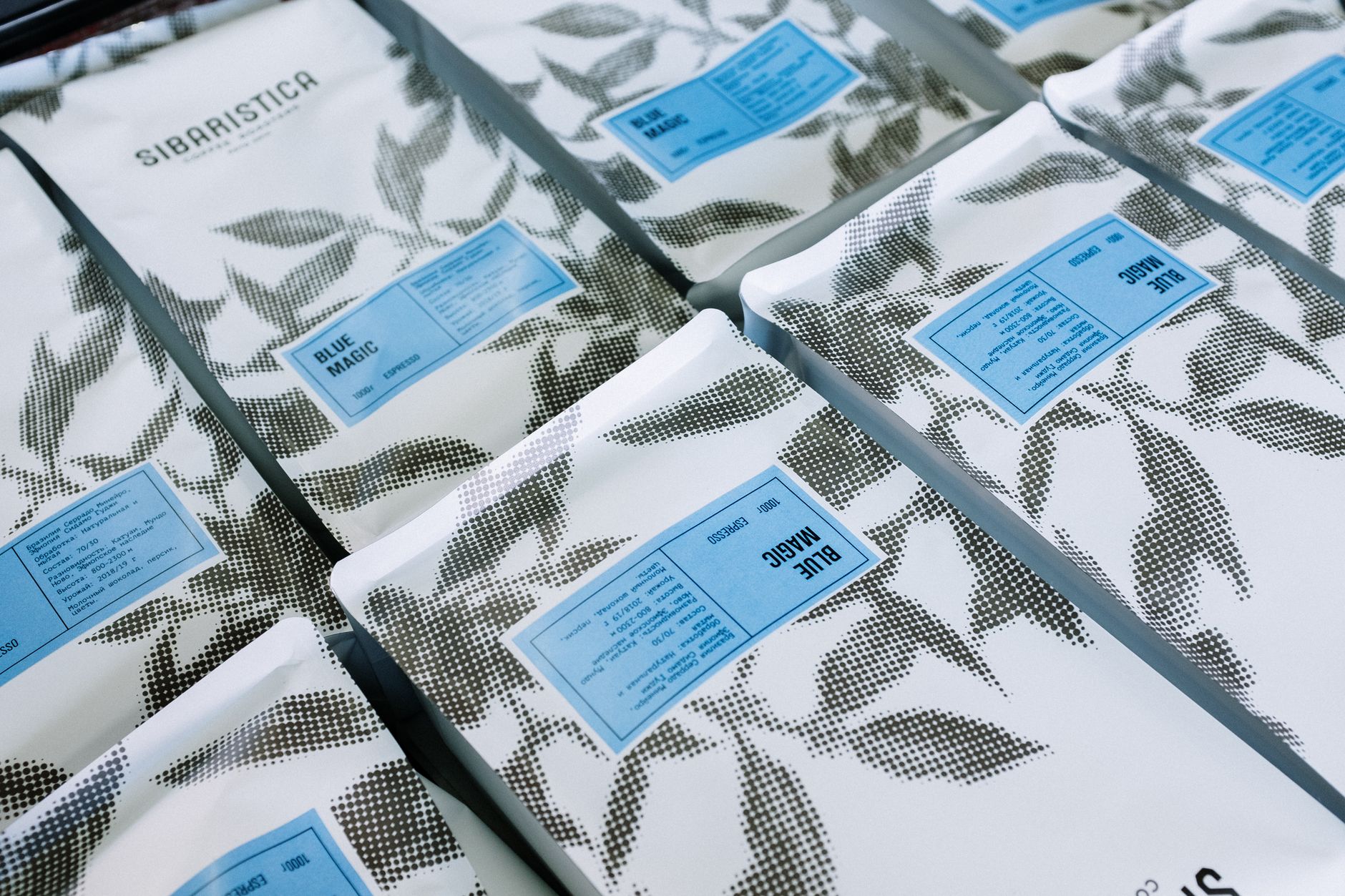 Coffee bag packaging samples with different label designs lined up on a table