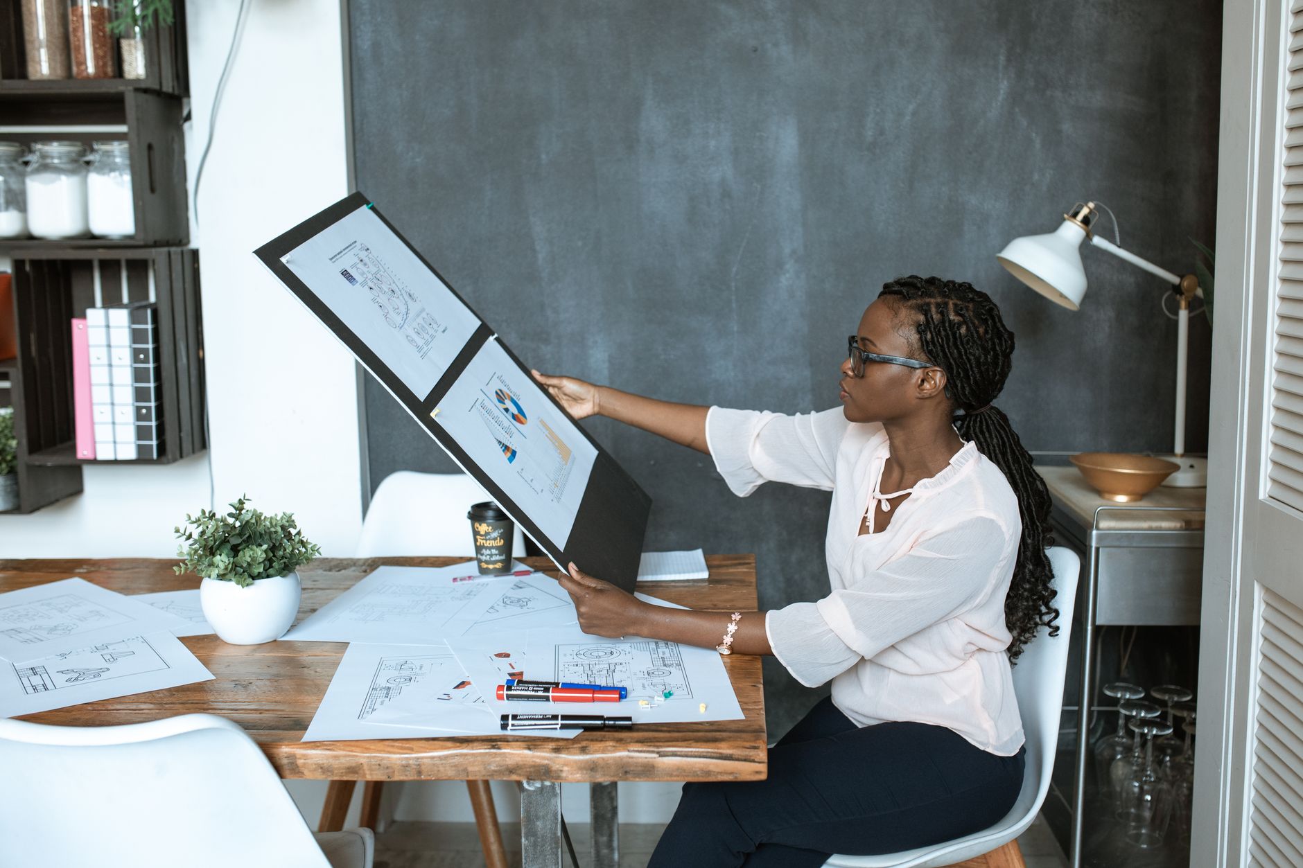 A printed proposal spread open on a meeting table beside a laptop and coffee cups