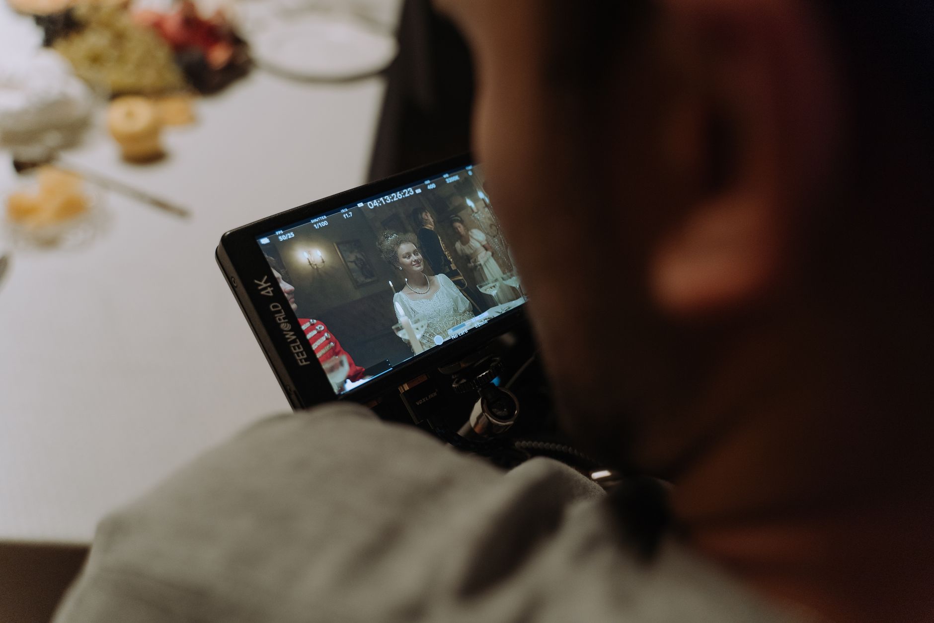 A field monitor on a cinema camera rig showing a framed shot