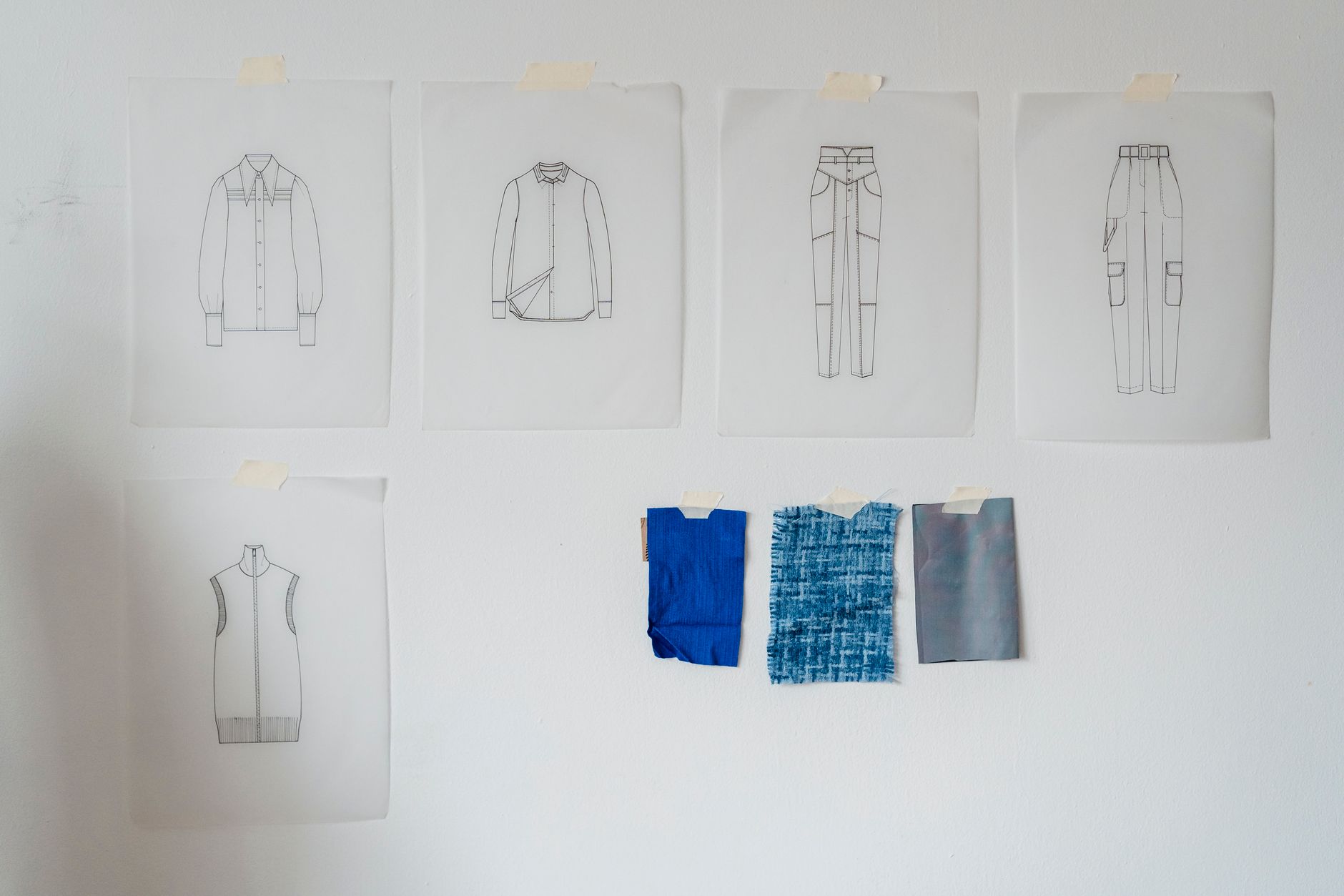Sketches and sticky notes pinned to a studio wall