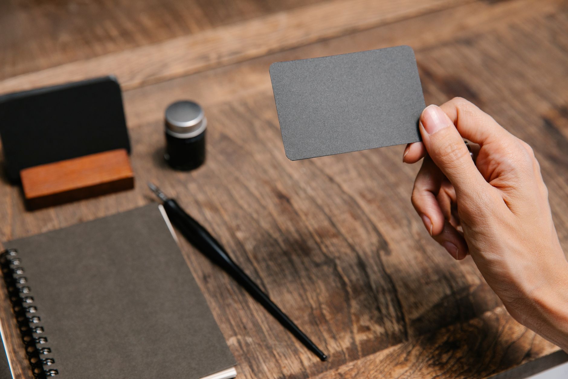 Printed brand identity mockups and colour swatches spread on a wooden desk