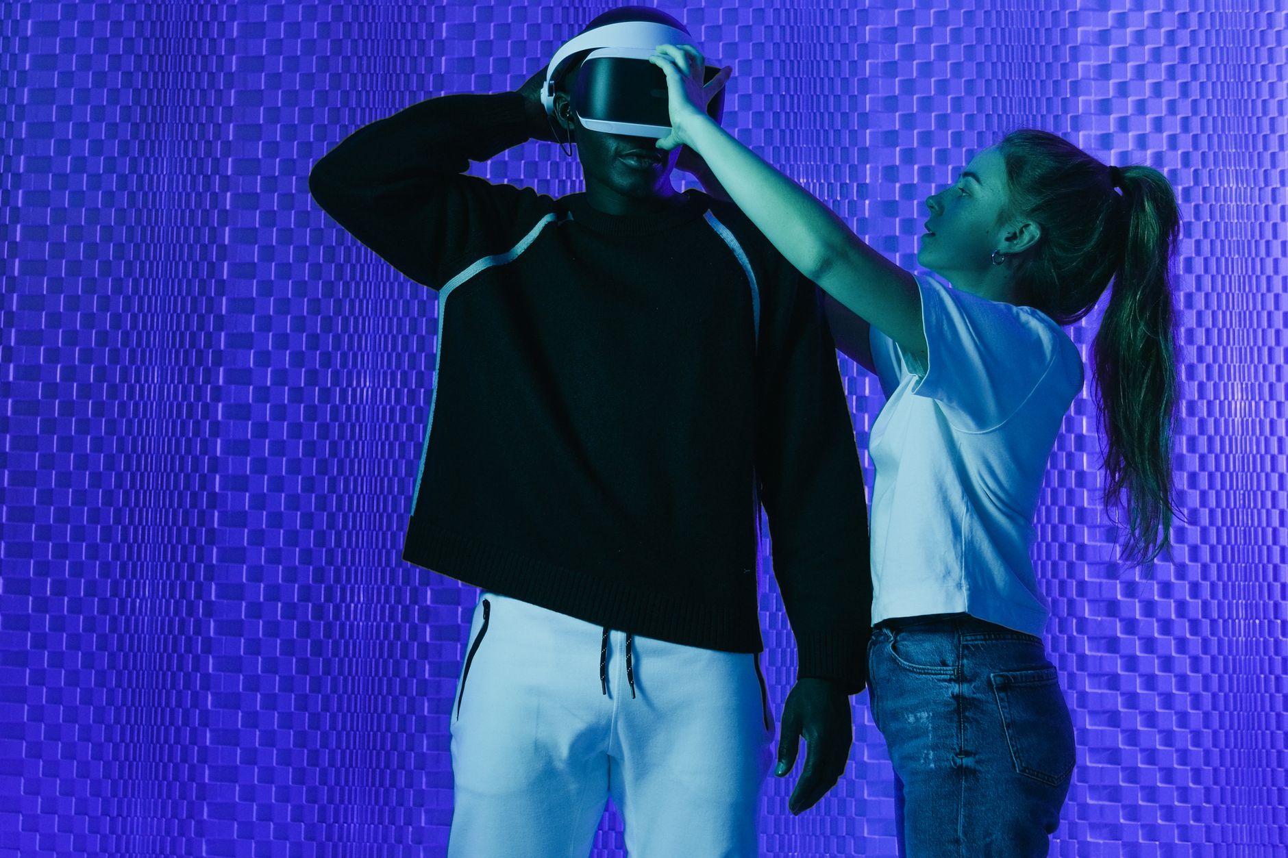 A designer wearing a VR headset in a bright studio, holding two controllers