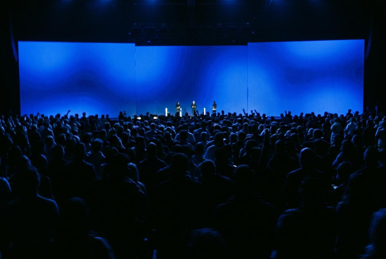 Crowd in front of a blue LED wall
