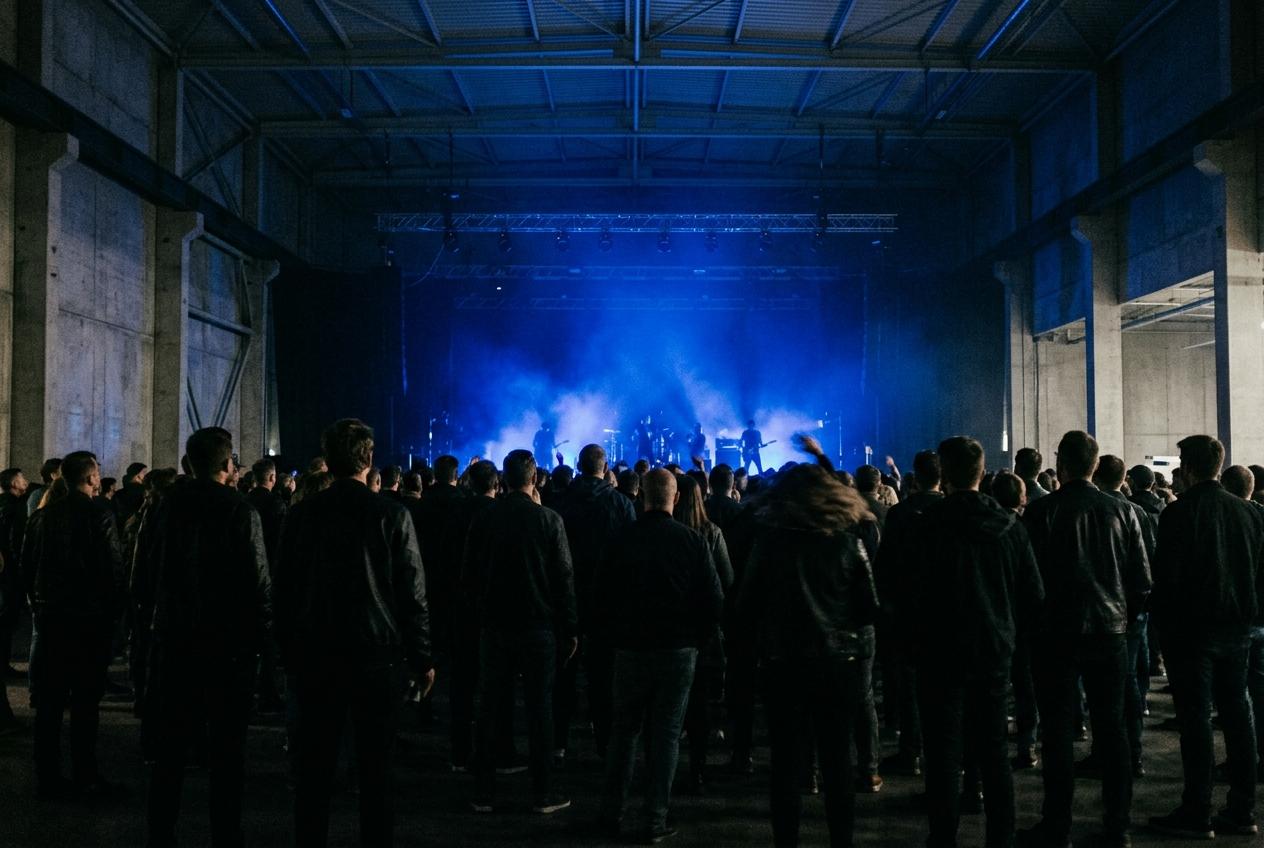 Crowd silhouetted against a stage wash